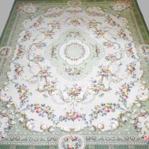 A mid 20th century carpet, with circular floral designs on a green ground, 355 x 273cm Quite