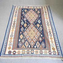 A Persian kilim rug, with diamond design, on a blue ground, 242 x 176cm