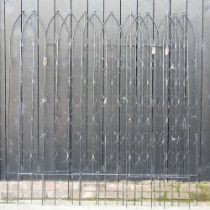 A collection of black painted metal garden trellis panels, of pointed arch design, each 181cm high