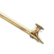 A brass curtain pole, the supports in the form of hands 142cm wide