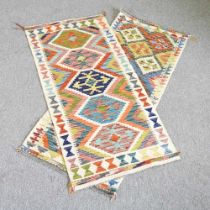A kilim runner, with a row of central diamonds, 152 x 62cm, together with another, 147 x 67cm (2)