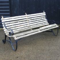 A wooden garden bench, 186cm wide, with scrolled metal ends