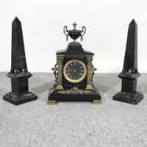 A Victorian black slate three piece clock garniture, surmounted by an urn, 39cm high, flanked by a