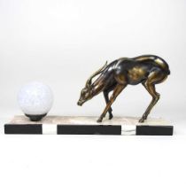 An Art Deco figural table lamp, surmounted by a deer and a glass shade, on a marble plinth base,