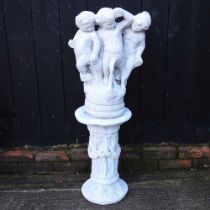 A cast stone garden statue, of three cherubs on a column base, 107cm high