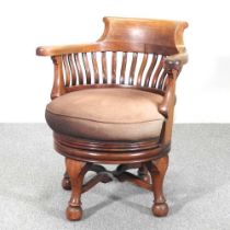 An Edwardian revolving desk chair, on cabriole legs, bearing a label for Cooke's (Finsbury) Ltd