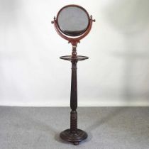 A 19th century carved rosewood shaving stand, with an adjustable circular mirror, on a fluted