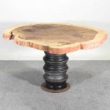 A rustic dining table, with a natural top, on a pedestal base, from four metal car wheels 140w x