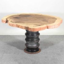 A rustic dining table, with a natural top, on a pedestal base, from four metal car wheels 140w x