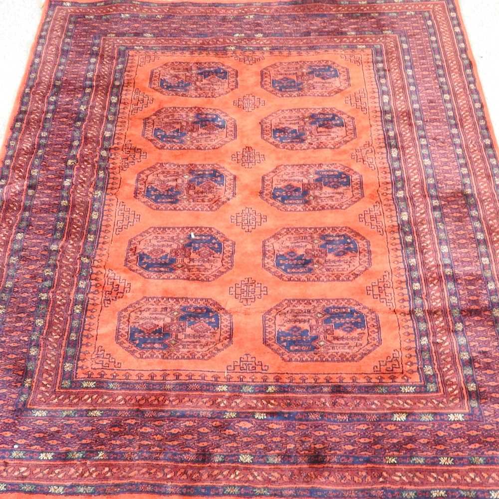 An Afghan rug, with two rows of medallions, on a red ground, 229 x 172cm