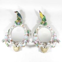 A pair of early 20th century continental porcelain girandoles, each of oval shape, with twin