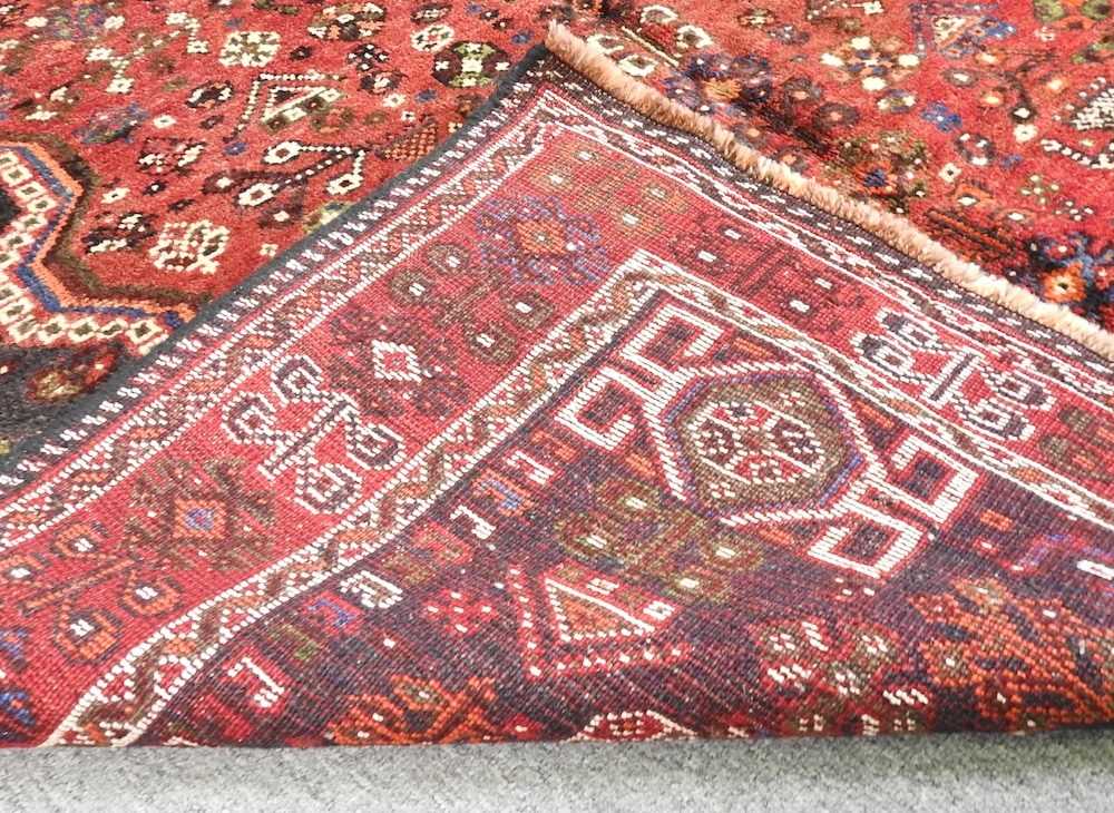 A Persian qashqai carpet, with all over designs and a central red medallion, 260 x 168cm - Image 3 of 3