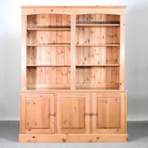 A modern pine bookcase, with open shelves and a doors below 158w x 46d x 200h cm