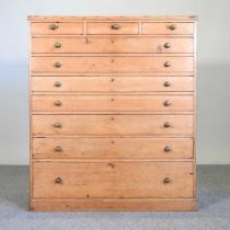 An early 20th century pine chest, containing an arrangement of ten graduated drawers, on a plinth