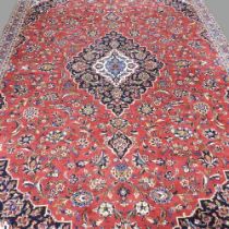 A Persian kashan carpet, with all over floral designs, on a red ground, 320 x 220cm