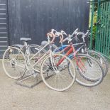 A ladies vintage Raleigh bicycle, with two others and a bike stand