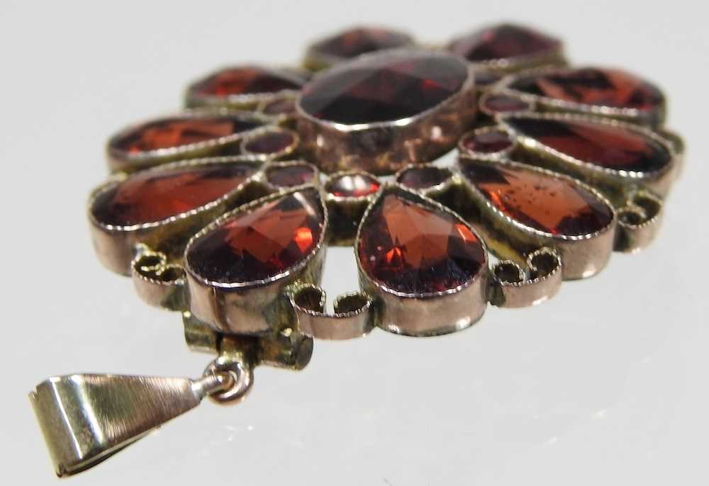 An unmarked two colour filigree garnet pendant, of flowerhead design, set with ten pear shaped - Image 3 of 4