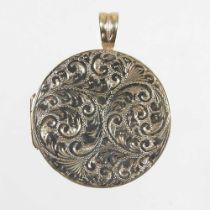 A gilt locket, of hinged circular shape, finely engraved with scrolling foliate designs, 17g, 35mm