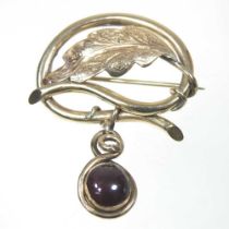 An unmarked gilt brooch, in the form of a leaf, suspended with a garnet, 4.4g, 32mm wide