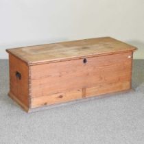 An antique pine box, with a hinged lid, flanked by iron handles 112w x 49d x 45h cm