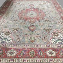 A Persian carpet, with floral designs on a sage green ground, 385 x 300cm