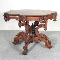 An ornate Victorian style carved centre table, with a shaped top, with foliate decoration 78w x 107d