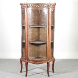 An early 20th century French marble top vitrine, of serpentine shape, with a pierced brass gallery