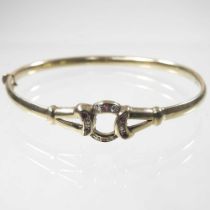 A 9 carat gold hinged bangle, set with rubies and diamonds, 7.5g, 65mm wide