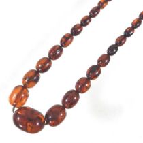 An amber coloured bead necklace, composed of a single row of graduated beads, largest 35mm wide,