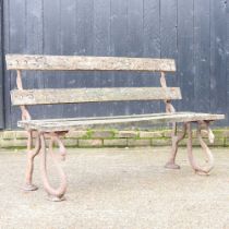 A Victorian design garden bench, with a slatted wooden seat, on cast iron serpent supports 133w x