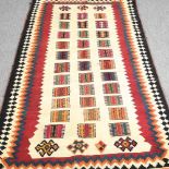 A Persian qashqai kilim, with coloured squares, within a zig zag border, 220 x 125cm