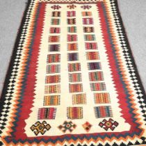 A Persian qashqai kilim, with coloured squares, within a zig zag border, 220 x 125cm