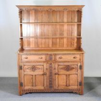 A mid 20th century carved oak dresser, with a boarded back 137w x 43d x 181h cm