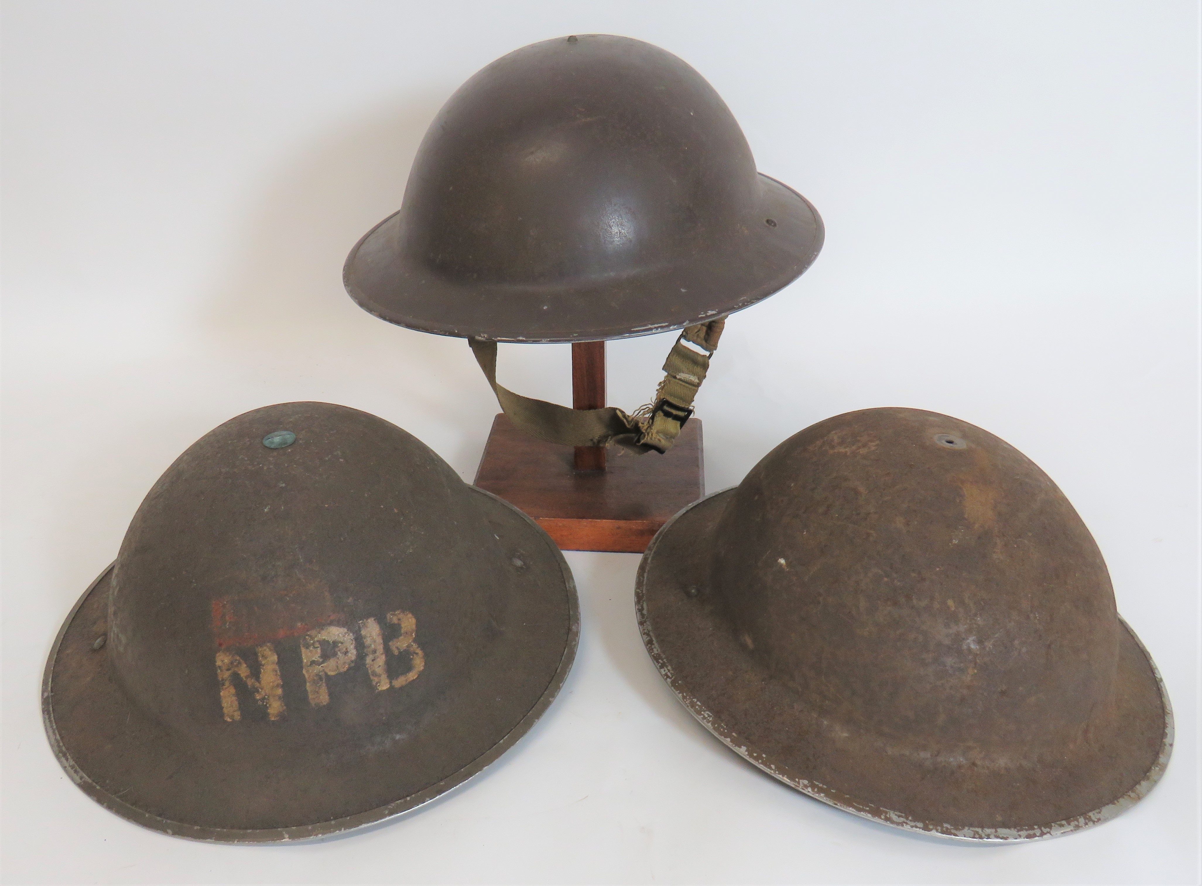 Three British Steel Helmets consisting brown painted shell.  Black treated linen liner.  Frame