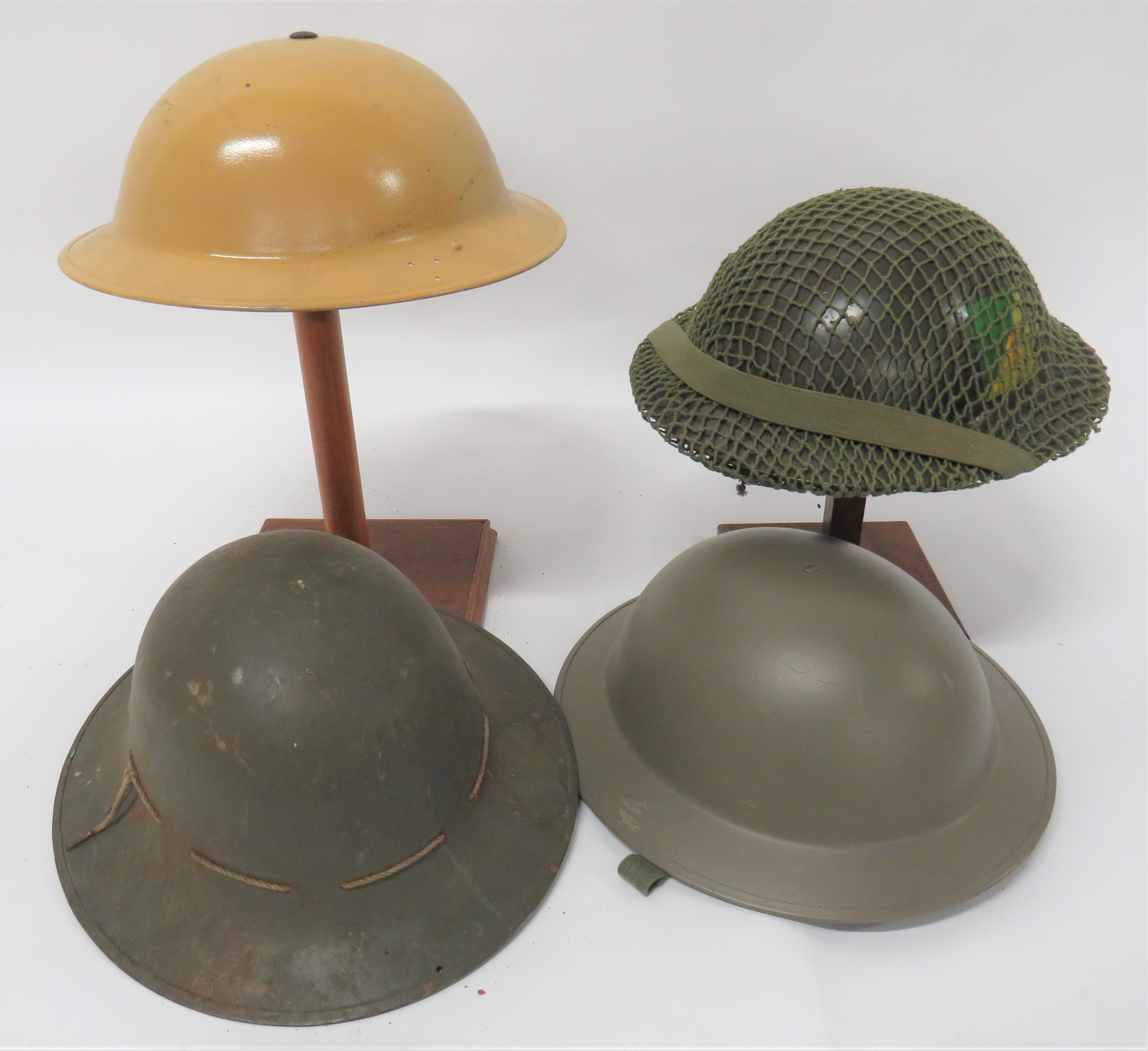 Four British Steel Helmets consisting khaki yellow, repainted, MKII helmet.  Side brim drilled