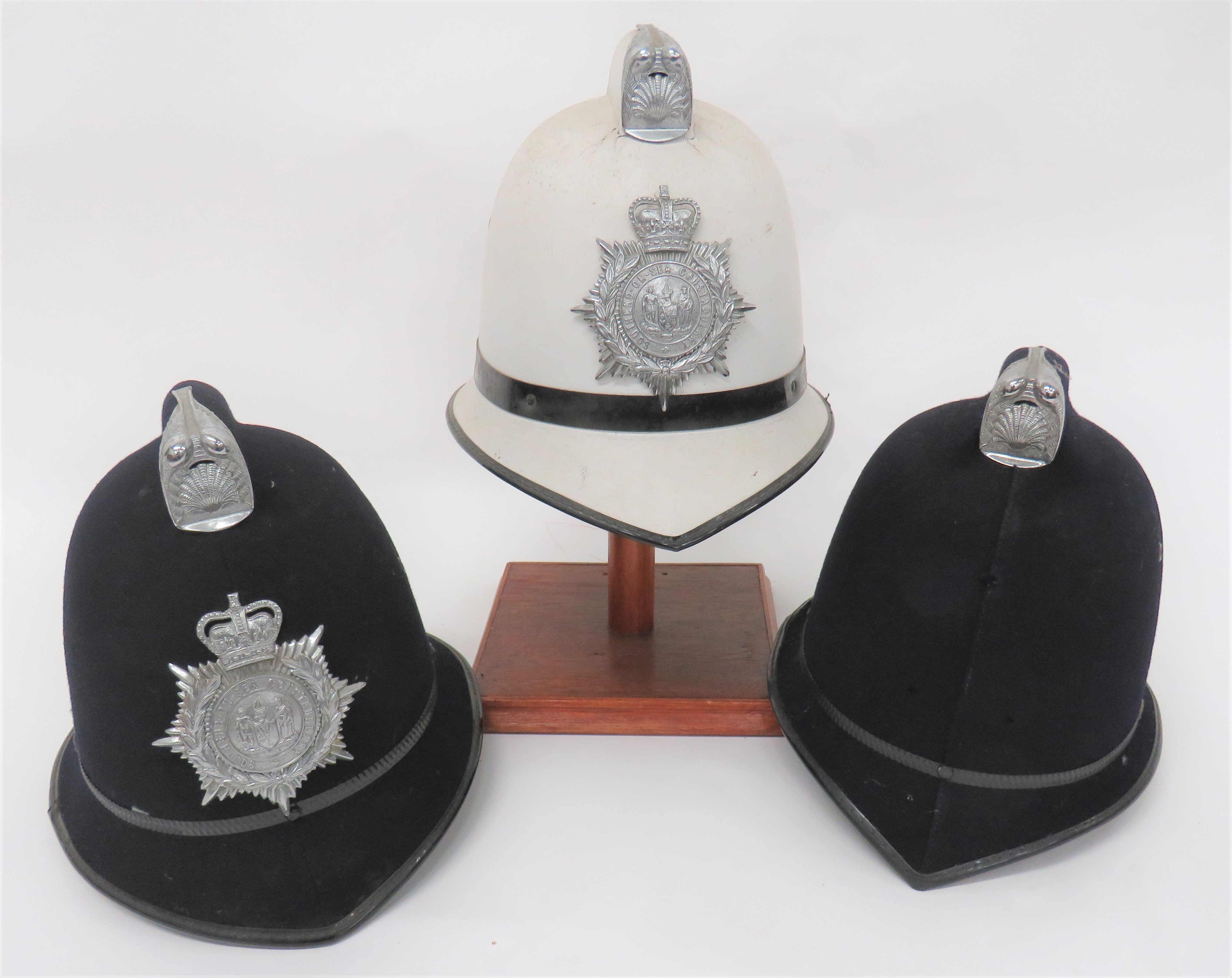 Three Various Police Constabulary Helmets consisting two panel, black felt, high crown with