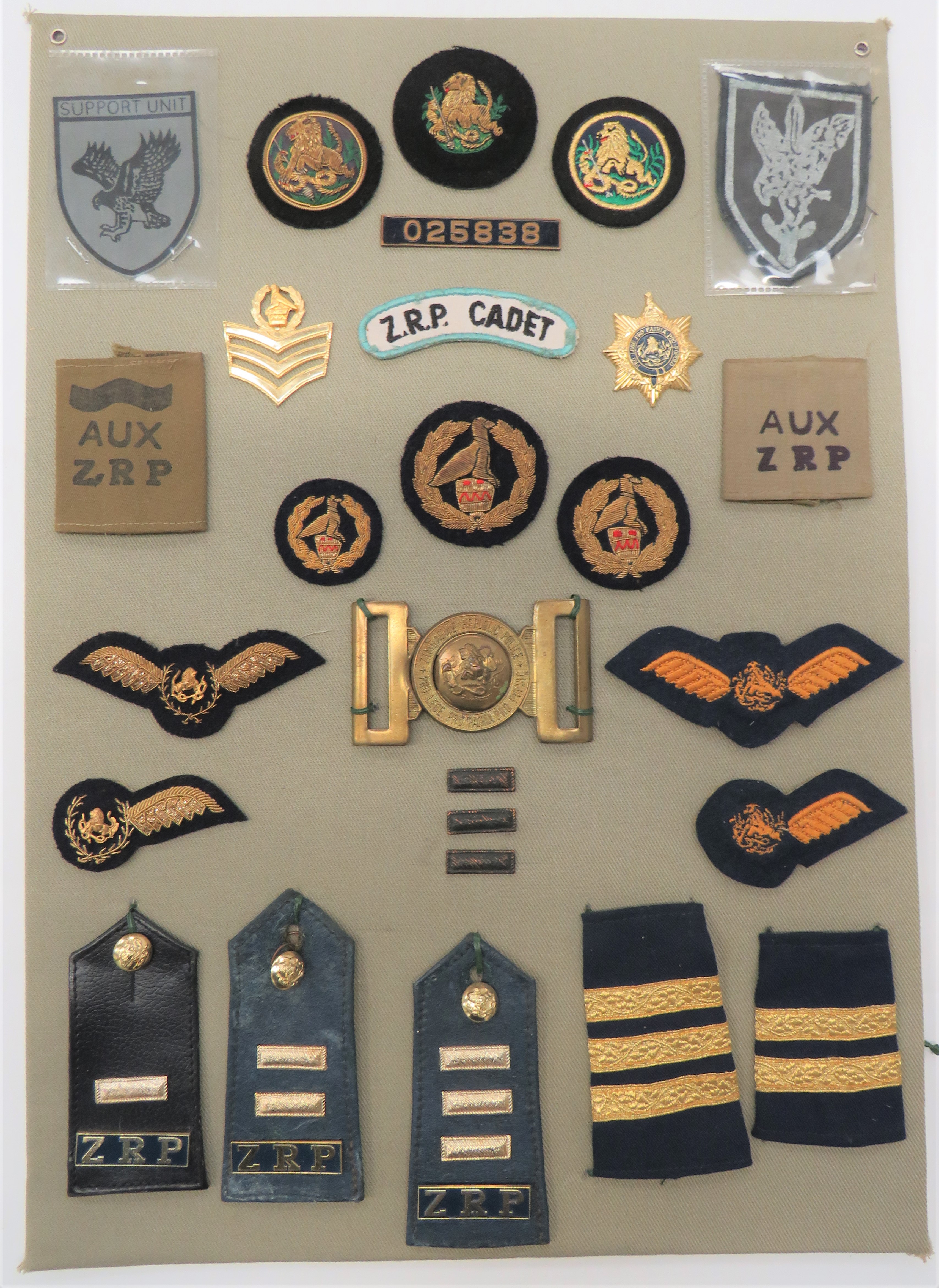 25 Items of Insignia For Zimbabwe Republic Police display board with good tabulated display of metal