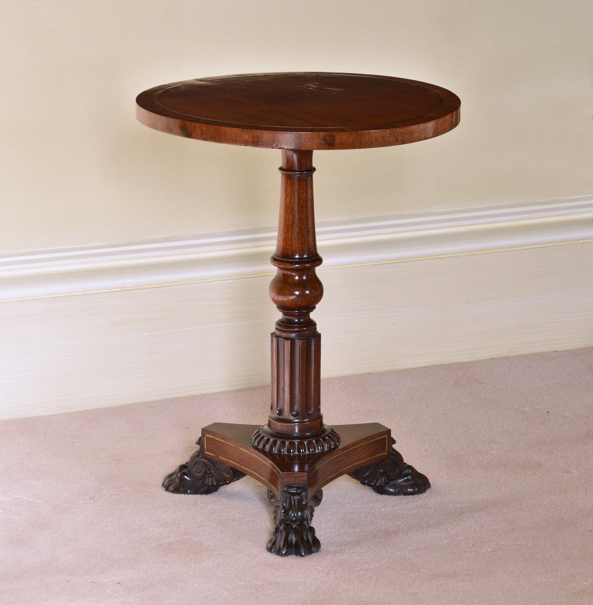 A William IV rosewood and brass circular occasional or wine table the brass strung top on a turned