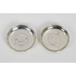A pair of Hong Kong silver pin dishes by Wai Kee, with inset HK junk dollar coins, 3½in. (9cm.)