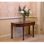 A George III mahogany D-shaped side table the deep frieze with hidden centre drawer, raised on