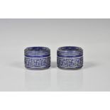 A pair of late Qing Chinese carved blue overlay glass ink boxes of circular form with covers, key