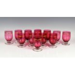 A set of twelve gilt and cranberry glass water glasses the tulip bowls with gilt lined decoration,