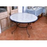 A circular wrought iron garden or conservatory table with mosaic top 47¼in. (120cm.) diameter, 29¼