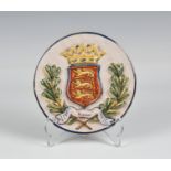 A Quimper HB 'Guernsey' circular plaque the plaque with raised Guernsey crest, two drill holes above