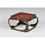 A Japanese lacquered wood square stand late 19th century, the red lacquer tray top on a black and