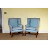 A pair of George III style wingback armchairs late 20th century, in blue studded upholstery,