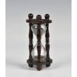 A 19th century treen hourglass of typical form, having turned bobbin supports, 4¼in. (10.8cm.)