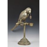 An amusing plated metal figure of a parrot on perch bird feeder raised on circular stepped base with