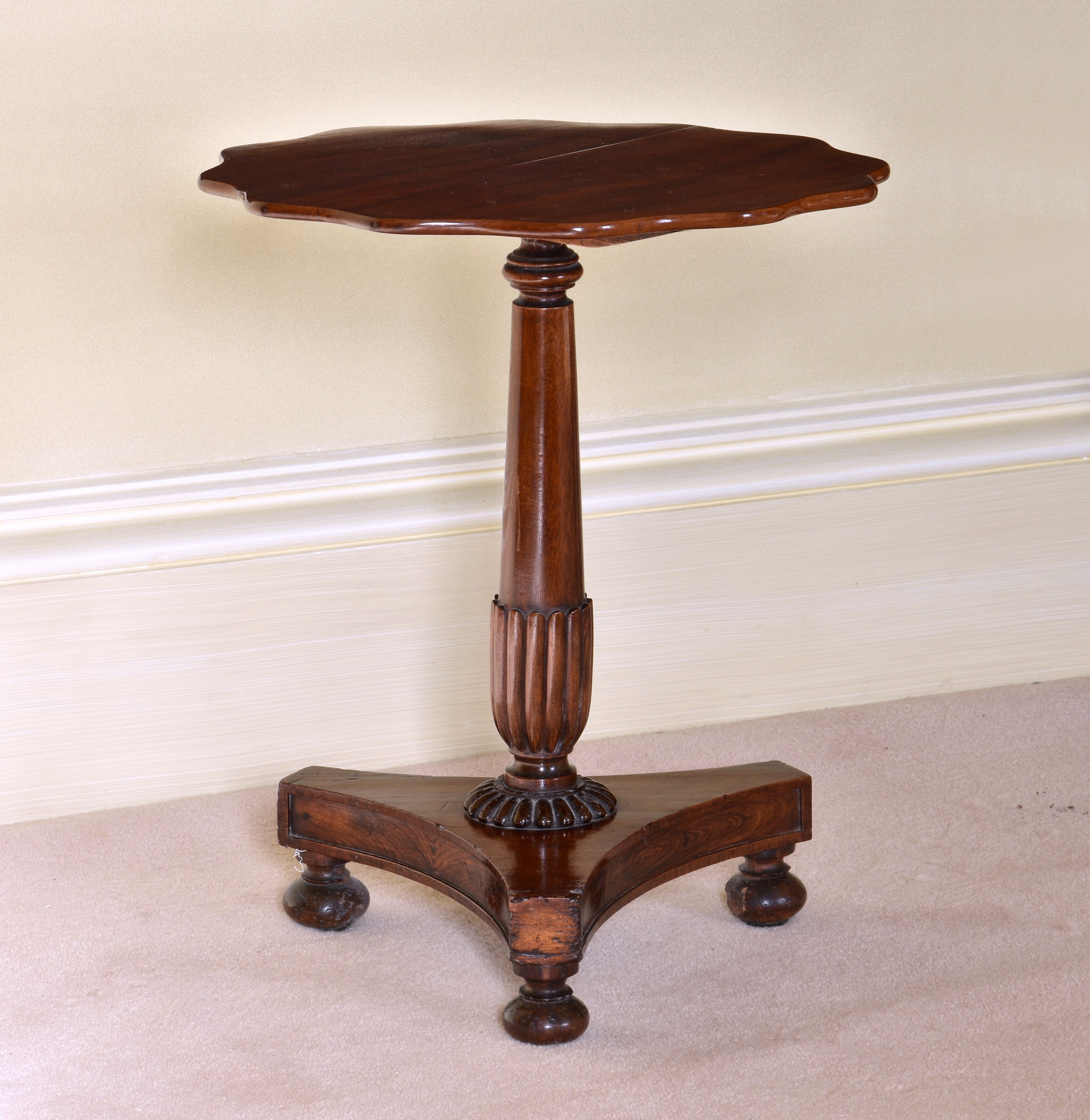 A William IV mahogany occasional or wine table the scalloped top on a part-reeded, turned column