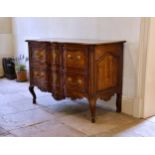 An 18th century French provincial walnut bombe two drawer commode the moulded top over two deep